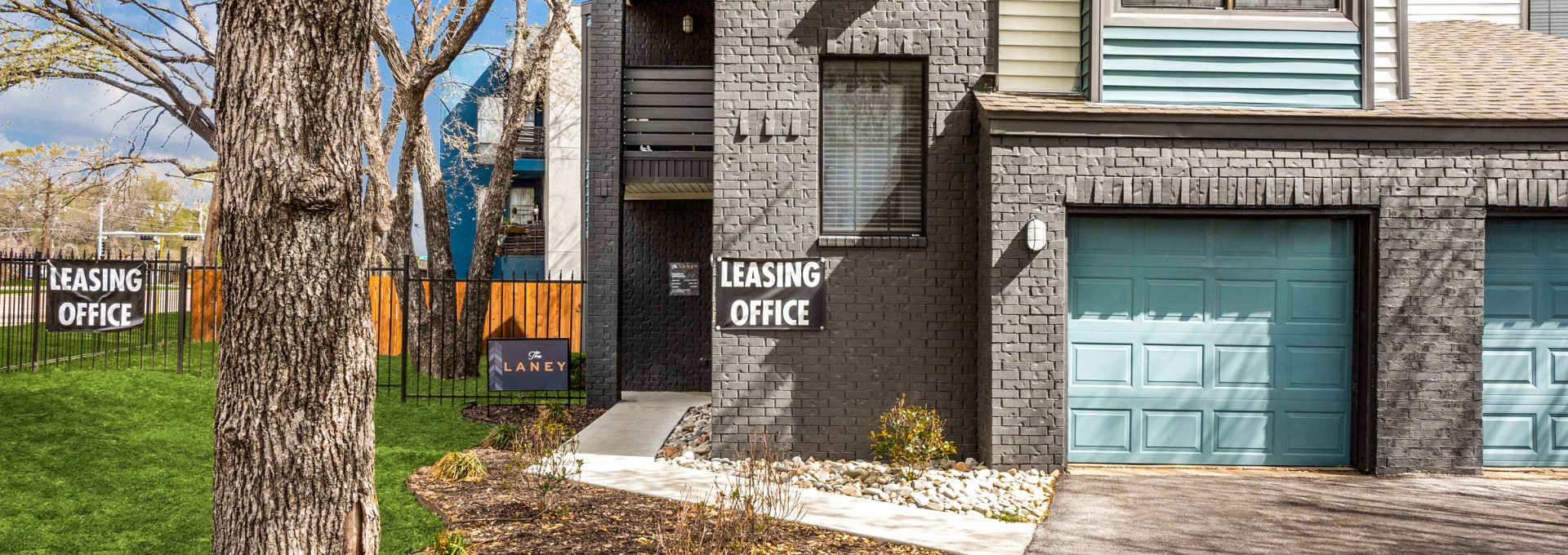 a two story townhouse with garage doors at The  Laney